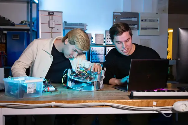 Två studenter arbetar med en prototyp i ett elektroniklabb.