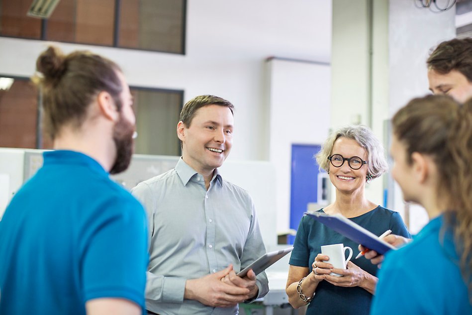 People in a group chatting, smiling. Photo.