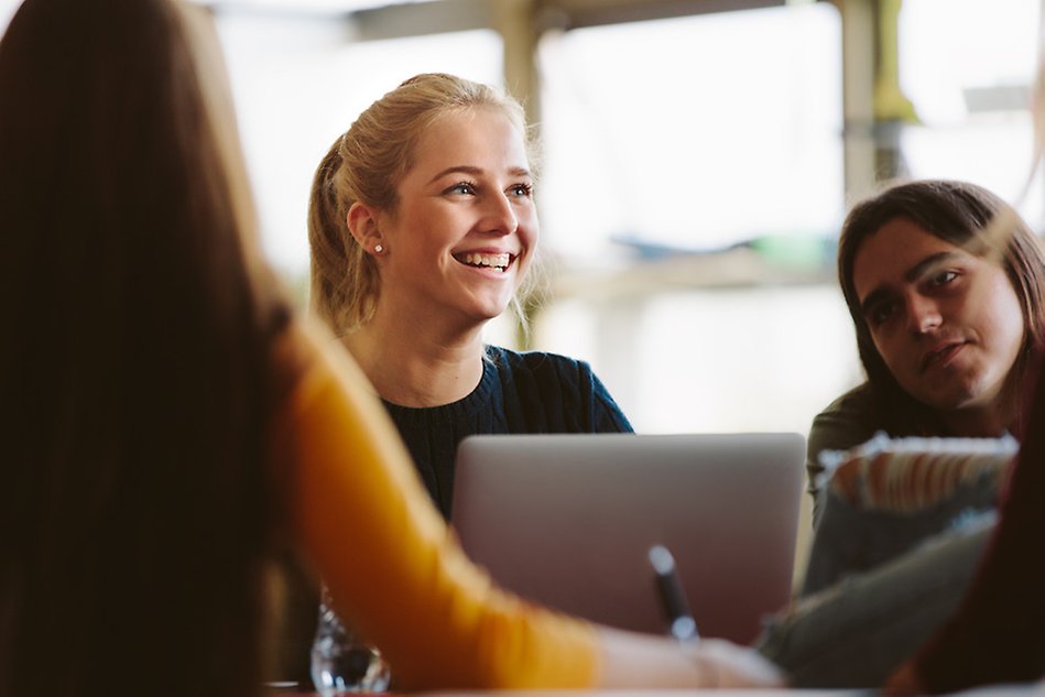 people standing in group chatting and smiling