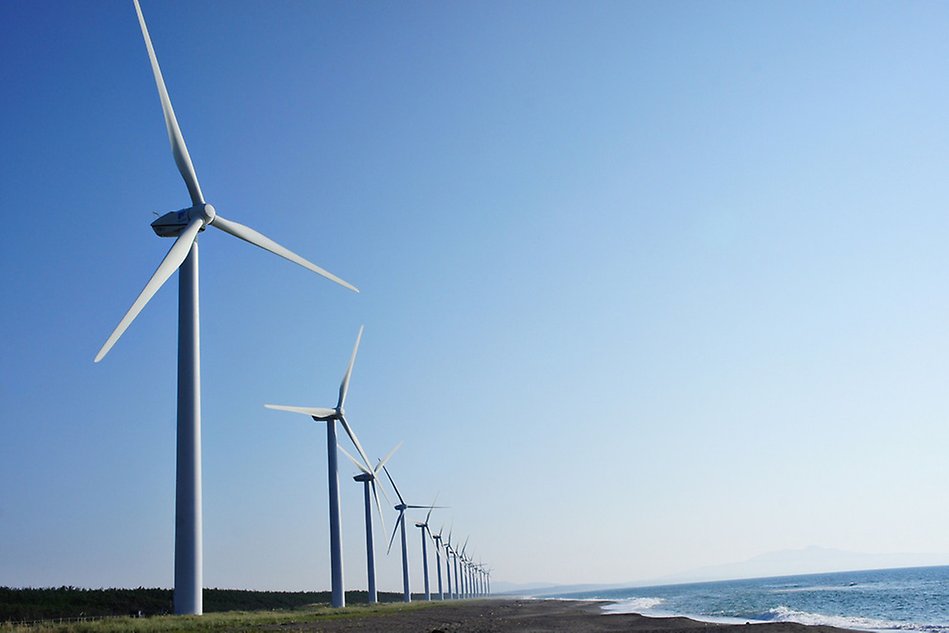 Several wind turbines on a beach. Photo.