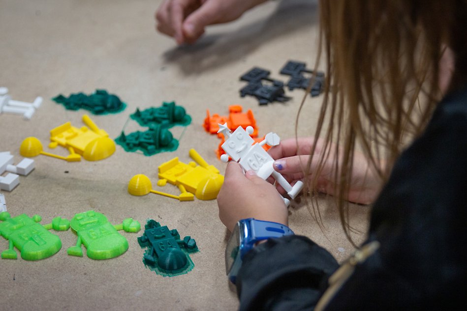 En femteklassare håller i en 3D-printad robot.