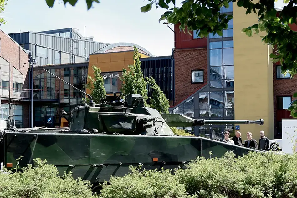 Stridsfordon utanför byggnad på campus
