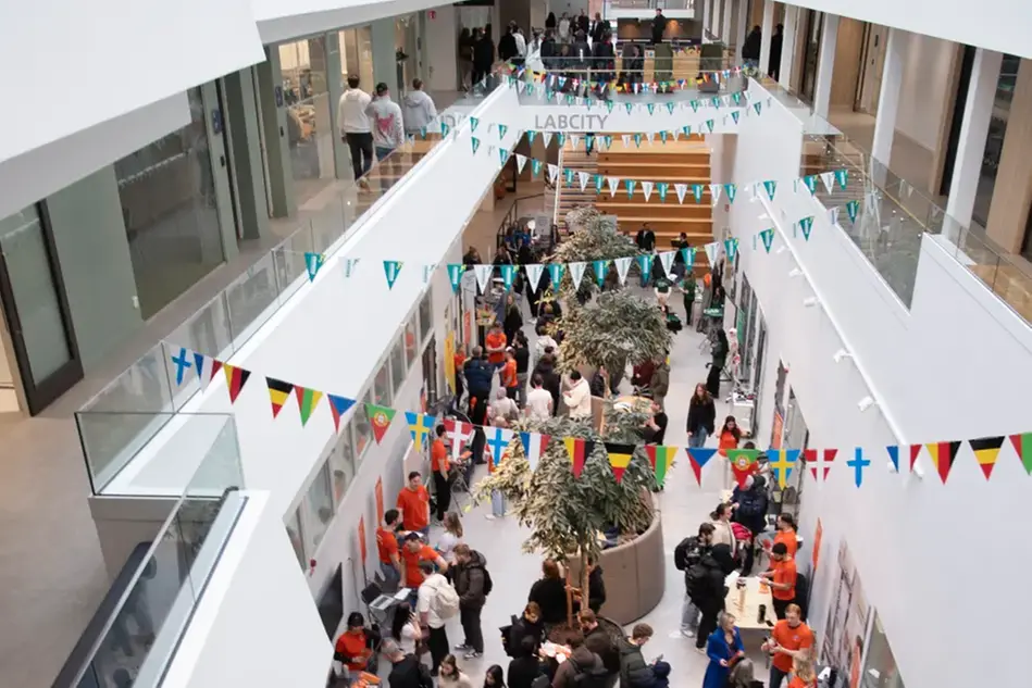 En ljus, öppen och avlång lokal med ett folkmyller.