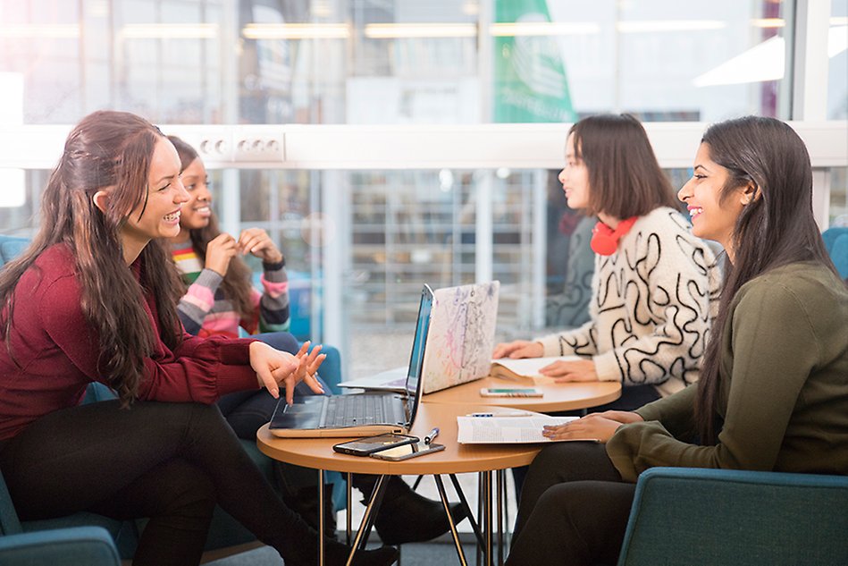 Three women are smiling and looking into the camera. Photo. 