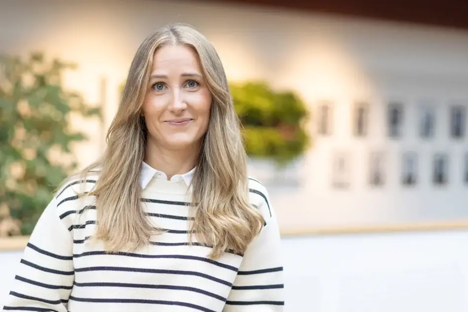 En person i inomhusmiljö som tittar in i kameran. Foto
