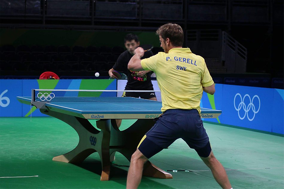 Två män spelar bordtennis. Foto.