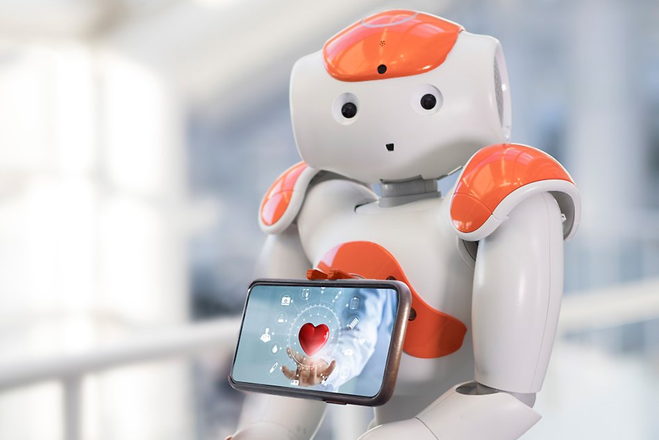A white and orange robot holding a tablet with a picture of a heart on it. Photo.