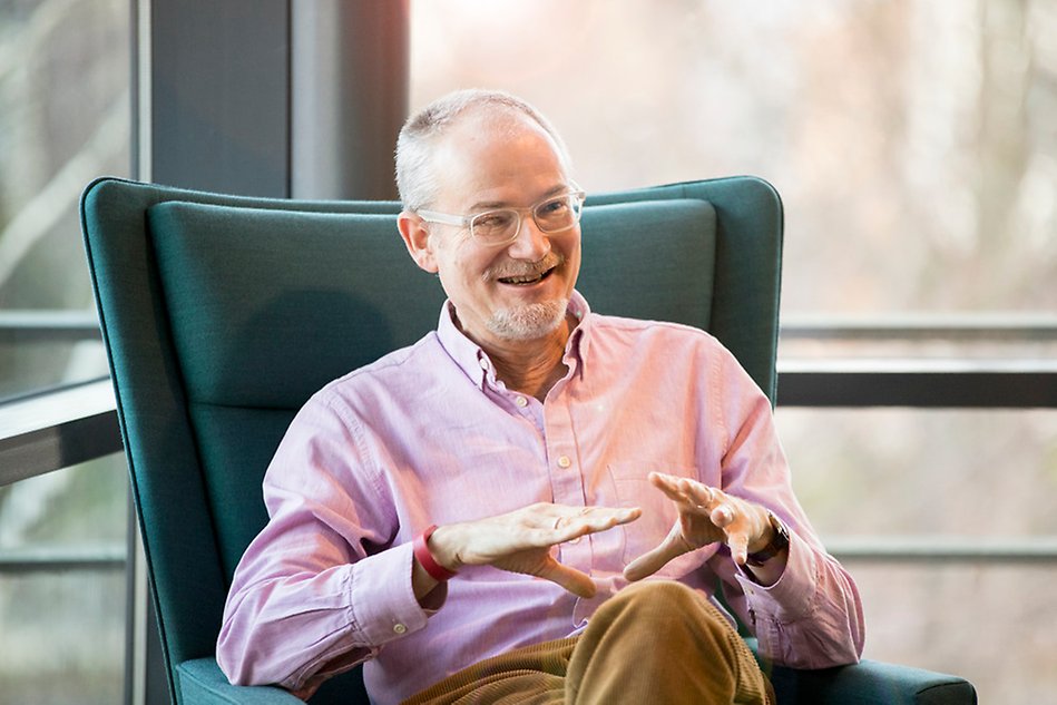 Man sitting in a green armchair talking.