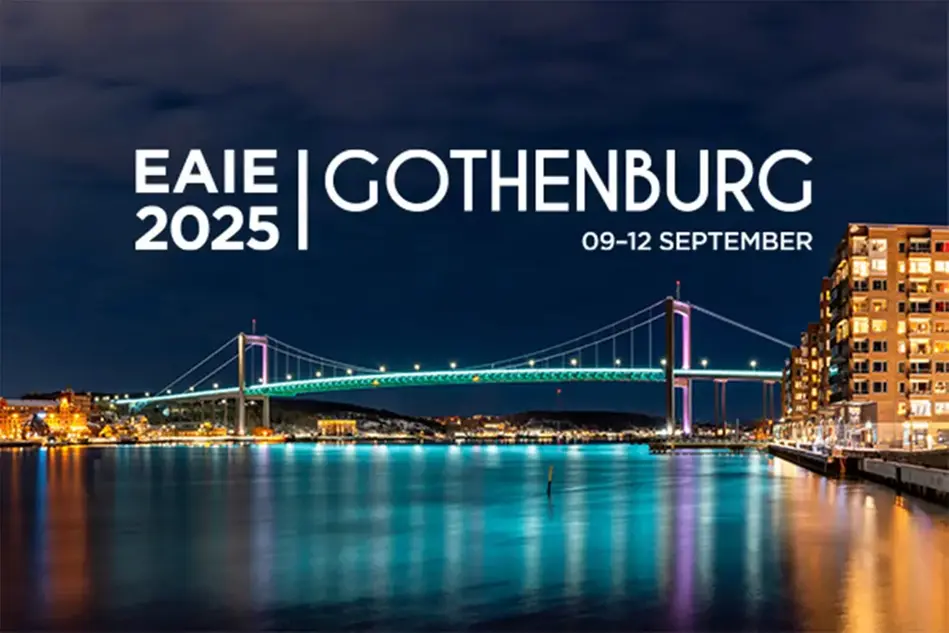 En bild tagen i mörker med en upplyst bro i fokus. Texten EAIE 2025 Gothenburg 09-12 september syns på.