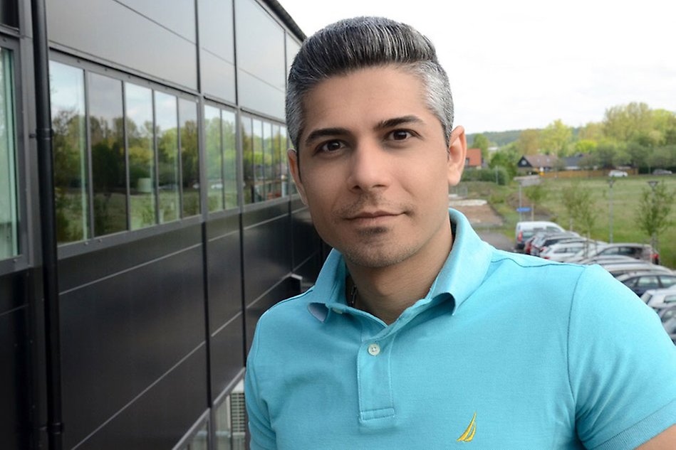 Man in blue shirt smiling at the camera.