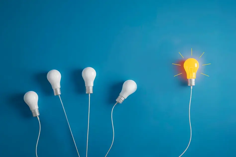 Five light bulbs against a blue background. One bulb shines yellow to symbolise an idea