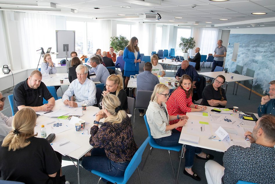 Participants in a workshop sit in small groups and talk to each other.