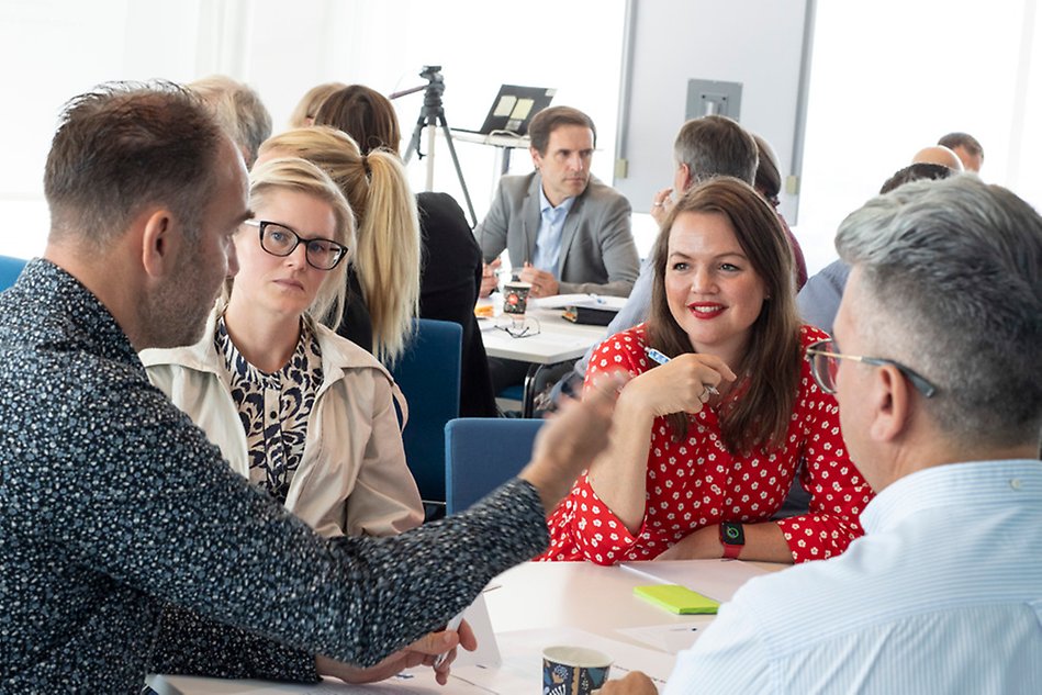 A group of participants engaged in conversation around a table.