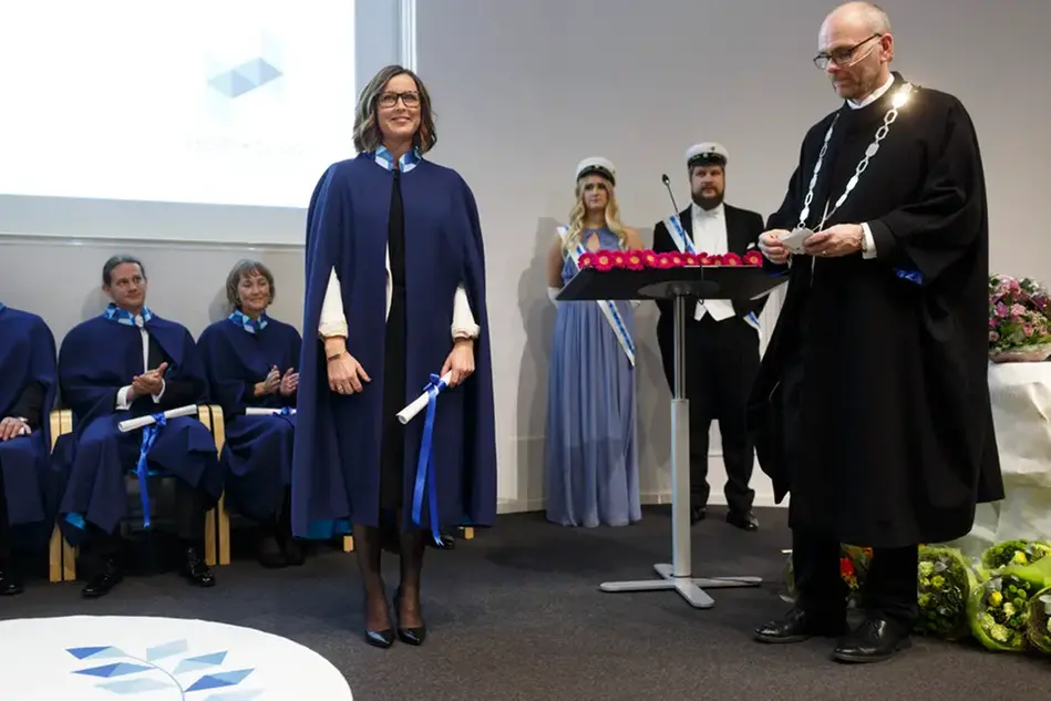 Personer i högtidsdräkter vid en ceremoni. Foto