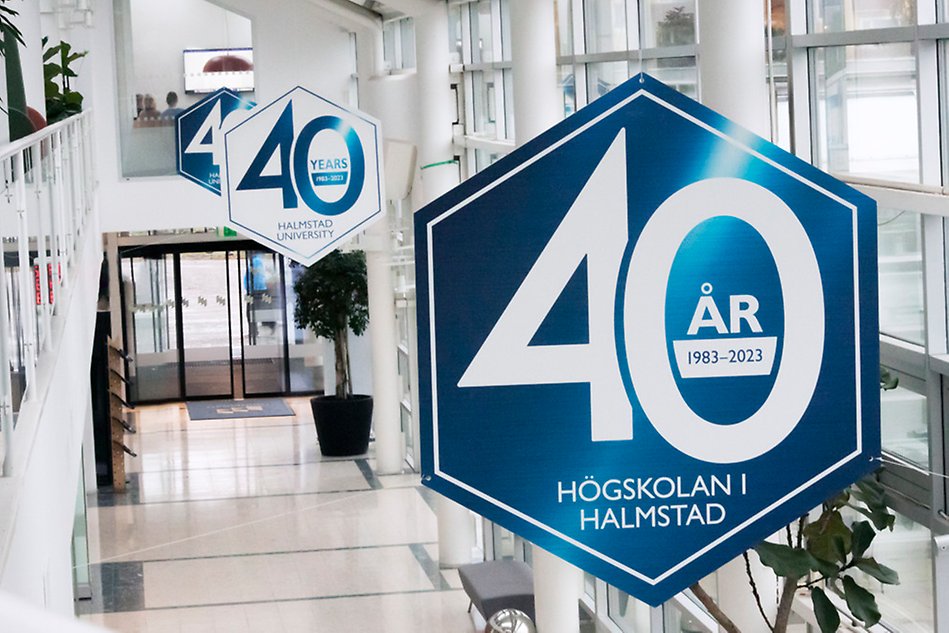 Large signs hanging from the ceiling, with the text Halmstad University 40 years. Photograph.