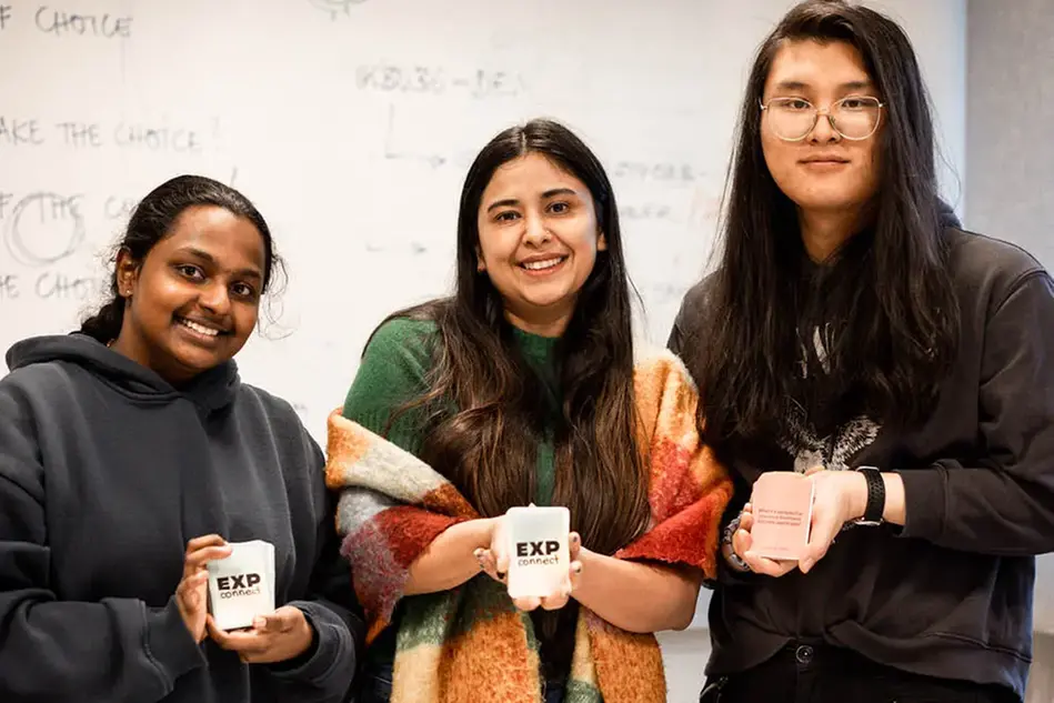 Three students showing their card game.