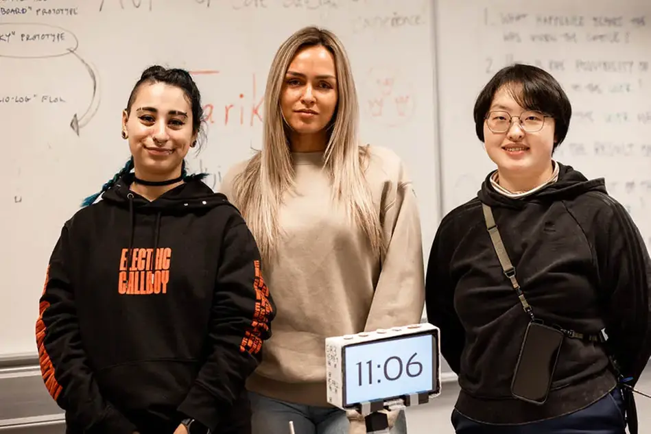 Three students showing their card game.