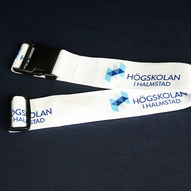 Två delar av ett vitt band med texten ”Högskolan i Halmstad” syns ovanifrån. Foto.