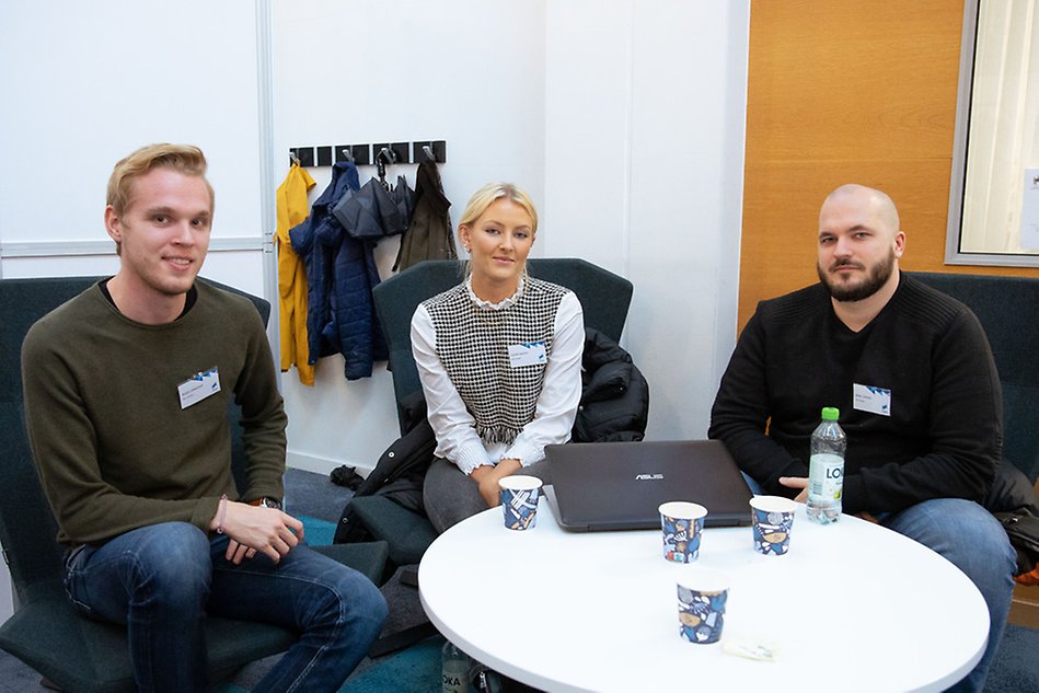 Three people sitting at a table.