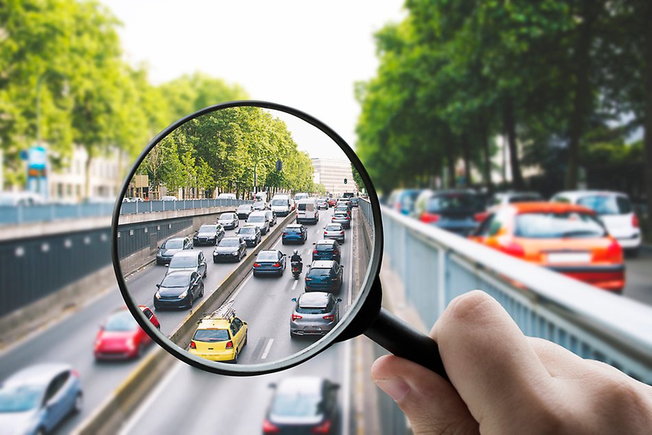 A magnifying glass over a traffic jam in a city. Photo