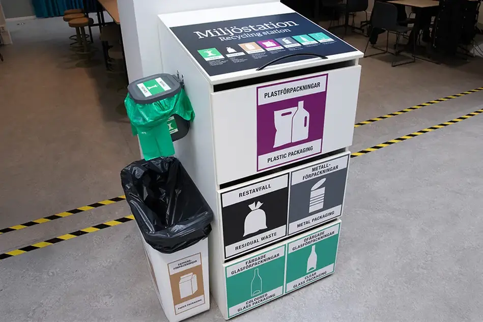 An recycling station with pull-out waste bins for items such as plastic, cardboard and metal.