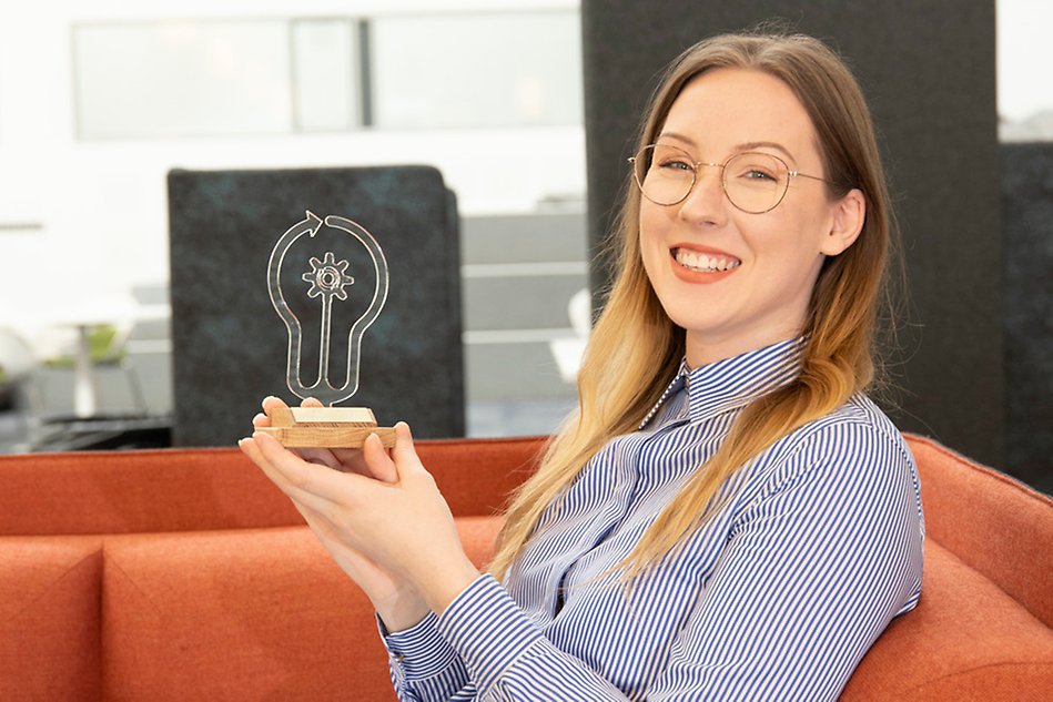 A woman is sitting in an armchair with a statuette in her hands.