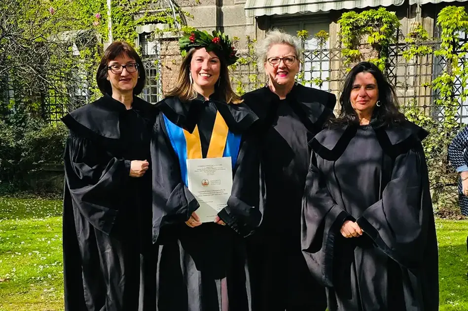 Fyra personer i svarta klädnader.