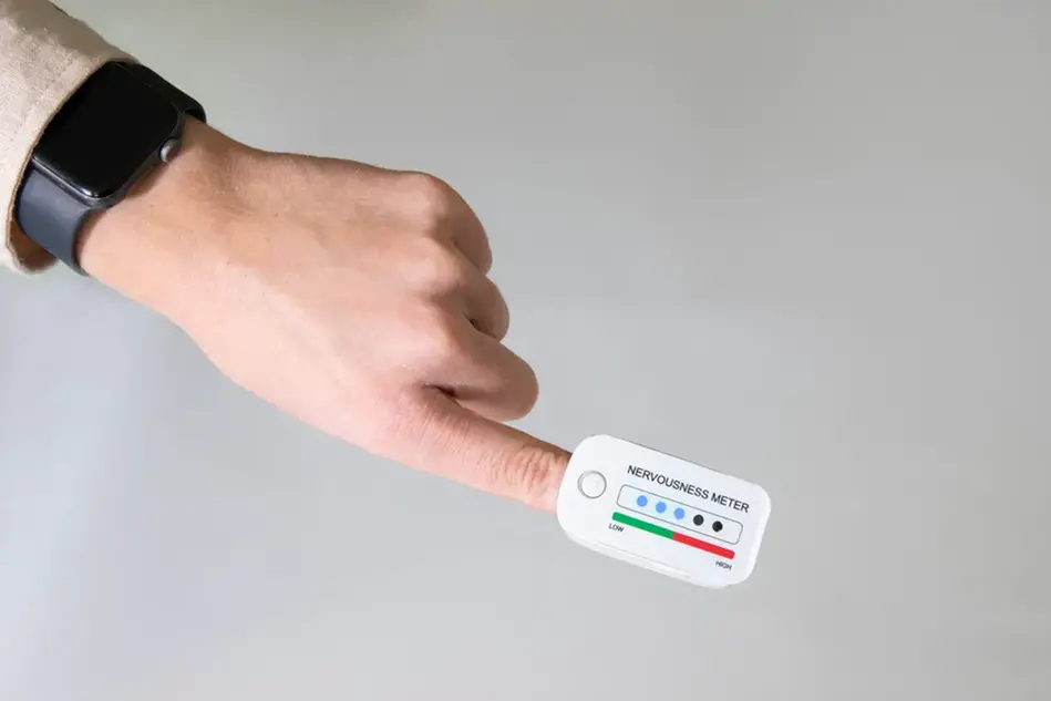 En hand som har något som ska föreställa en elektronisk enhet på pekfingret. Foto