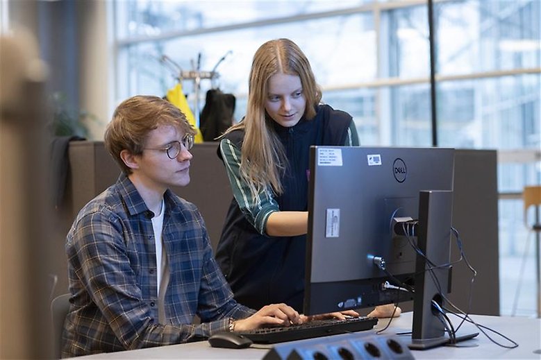 Två studenter tittar på en bildskärm