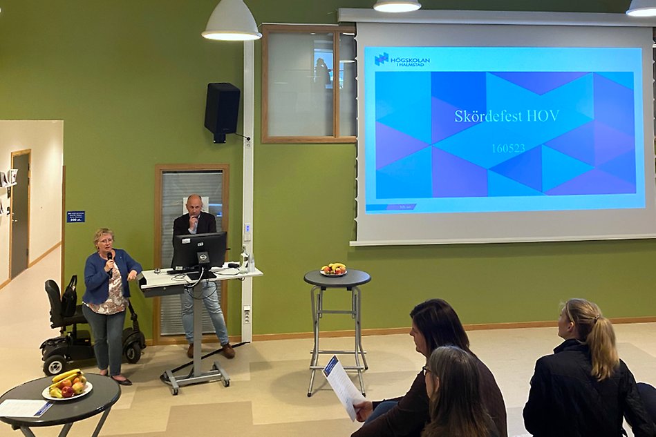 En man och en kvinna står framför en presentationsskärm. Foto.