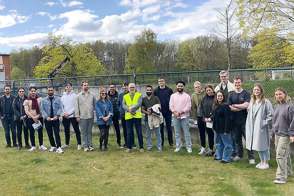 Gruppbild på lärare, forskare och studenter utomhus på en gräsmatta. Foto.