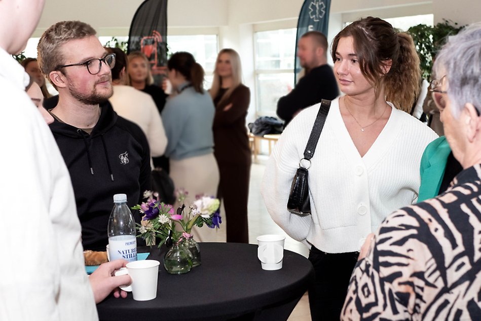 Två studenter minglar efter sina presentationer