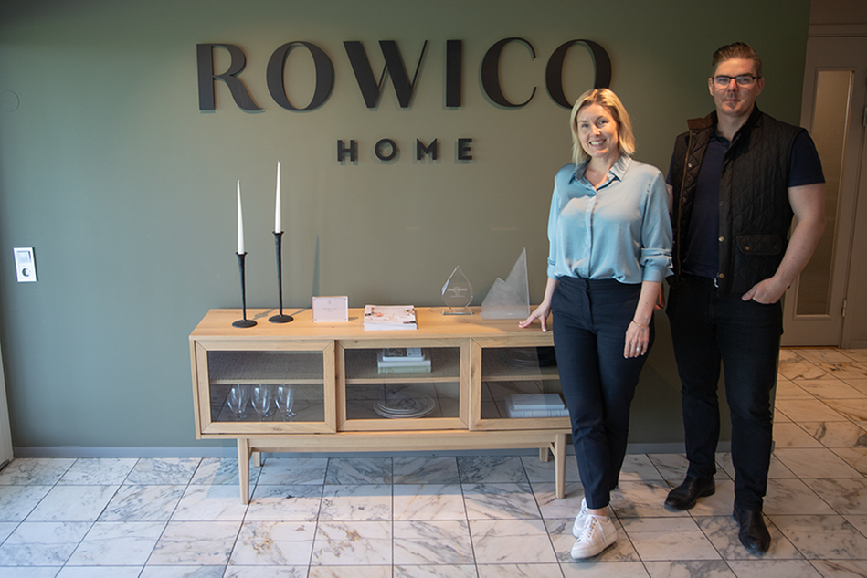 En kvinna och en man står framför en logotyp där det står ”Rowico Home”. Foto.