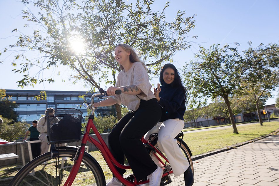 Två unga personer på en cykel.